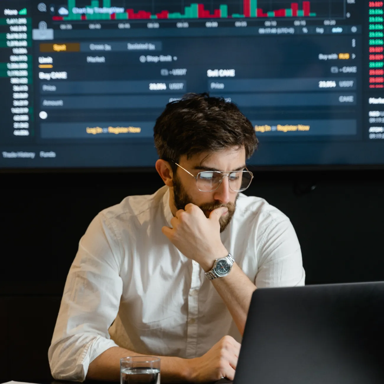 A man sitting in front of a computer working on a code.